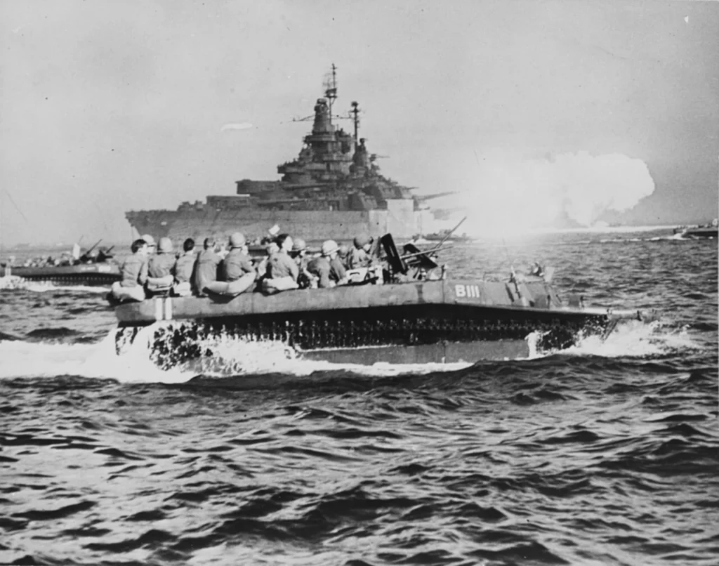 沖縄本島の上陸海岸へ向かう米軍の水陸両用車と沖合の戦艦