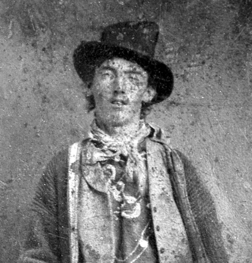 銃を持って立つビリー・ザ・キッドの肖像写真