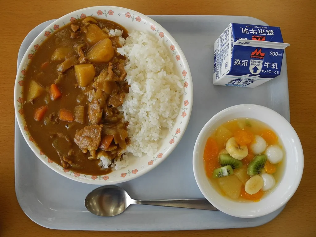 カレーライスと牛乳、フルーツサラダを組み合わせた日本の学校給食