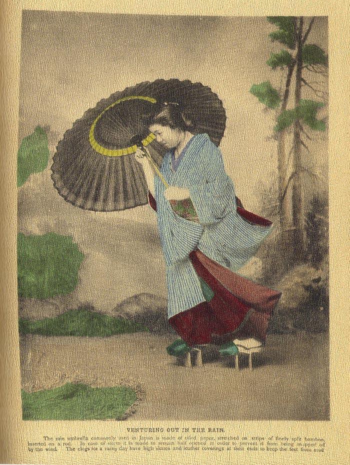 和傘を差して雨の中を歩く日本人を写した彩色写真