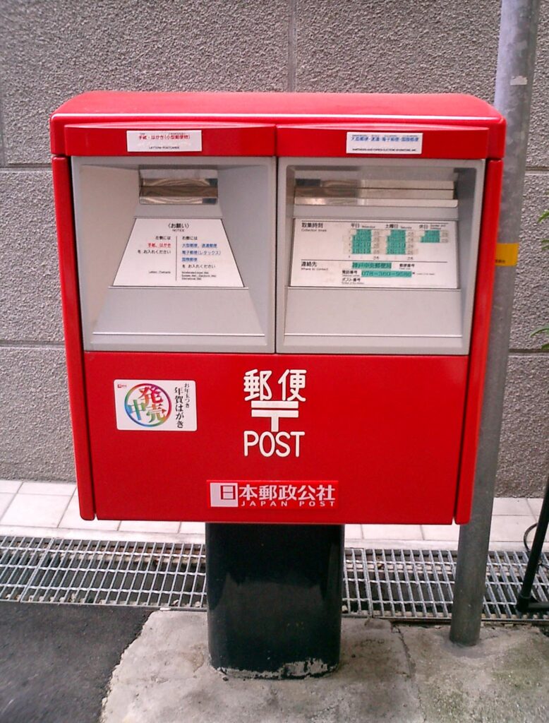 郵便記号が表示された日本の赤い郵便ポスト