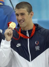 2008年北京五輪の表彰台で金メダルを示すマイケル・フェルプス
