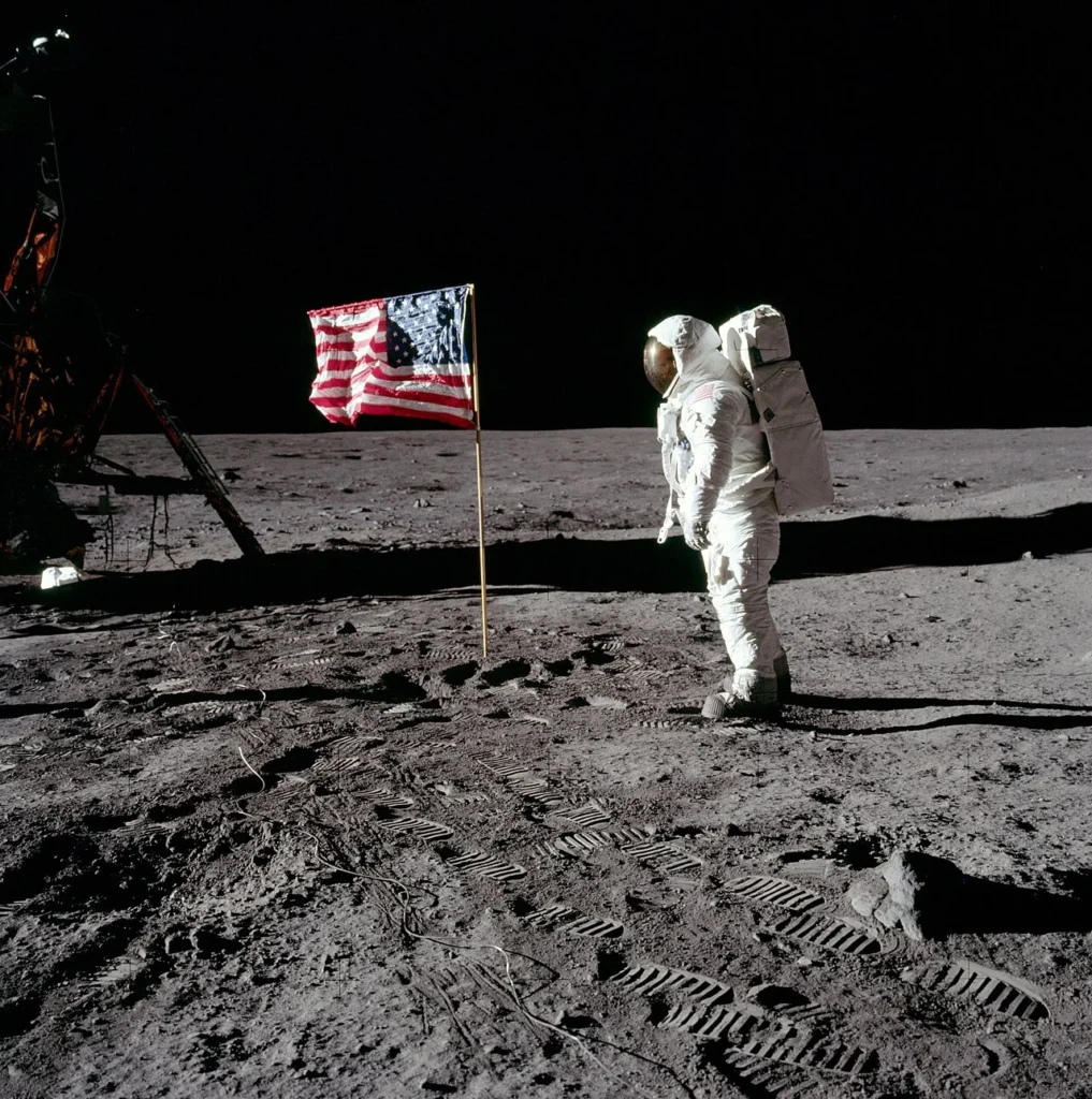 月面のアメリカ国旗のそばに立つアポロ11号宇宙飛行士バズ・オルドリン