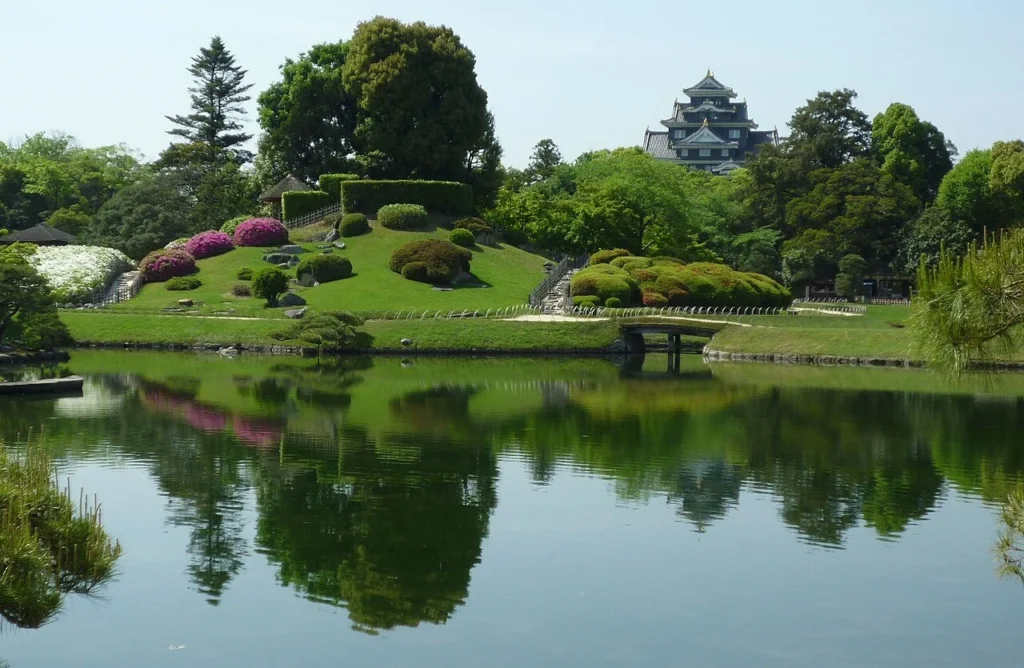 岡山後楽園の沢の池と唯心山、岡山城天守の写真