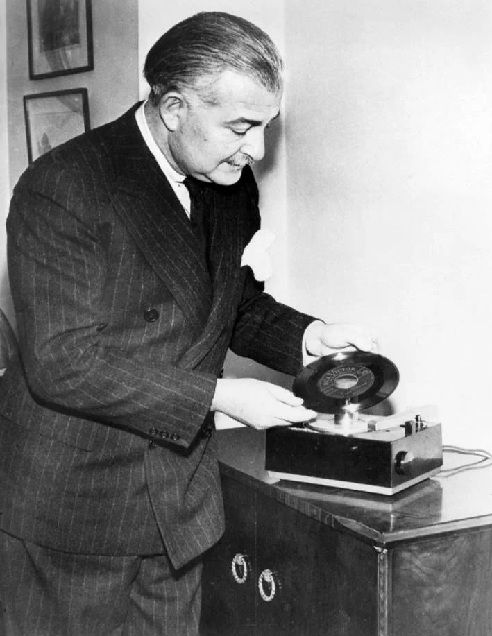 RCAの45回転レコードプレーヤーとレコードを実演するアーサー・フィードラー