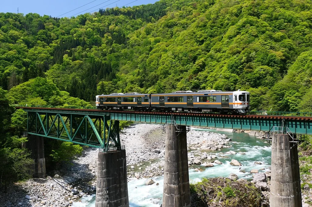 高山本線の宮川橋梁を渡る列車の写真