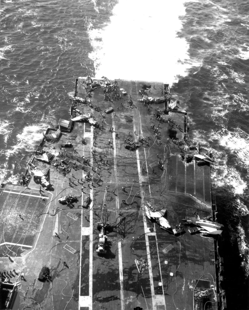 飛行甲板後部から煙を上げる原子力空母エンタープライズを上空から見た写真
