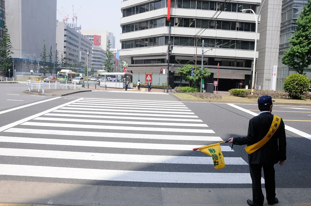 日本の道路横断の安全を見守る人の写真