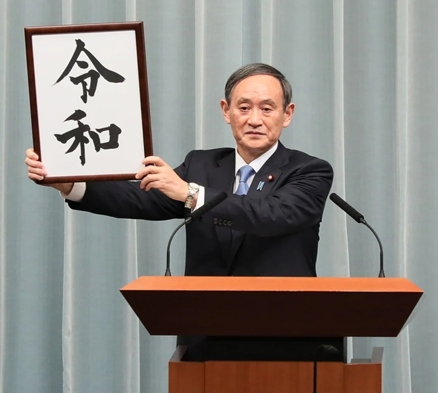 新元号「令和」の墨書を掲げる菅義偉官房長官